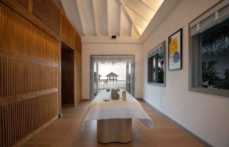 Tranquil Treatment Area: Wooden Dividers Surround a Table with Moksha Tools, Offering a Serene View of Floating Cottages on the Ocean