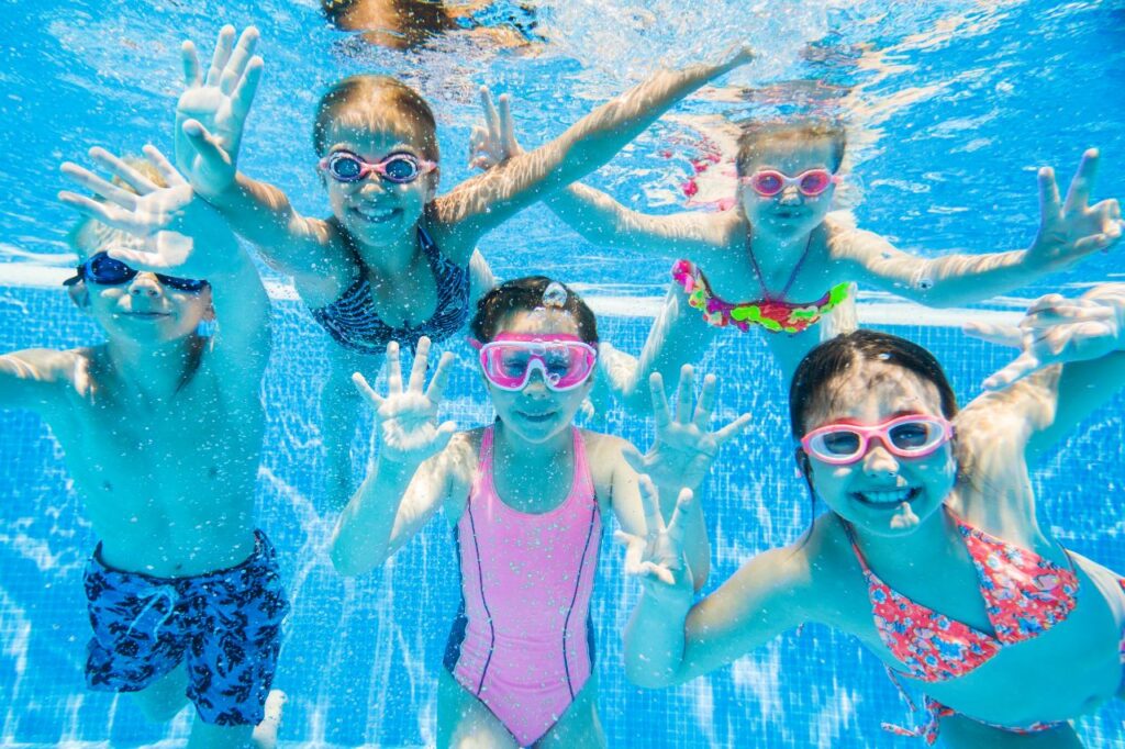 Joyful Kids Capturing Memories Under the Pool: Fun and Laughter in a Poolside Photoshoot