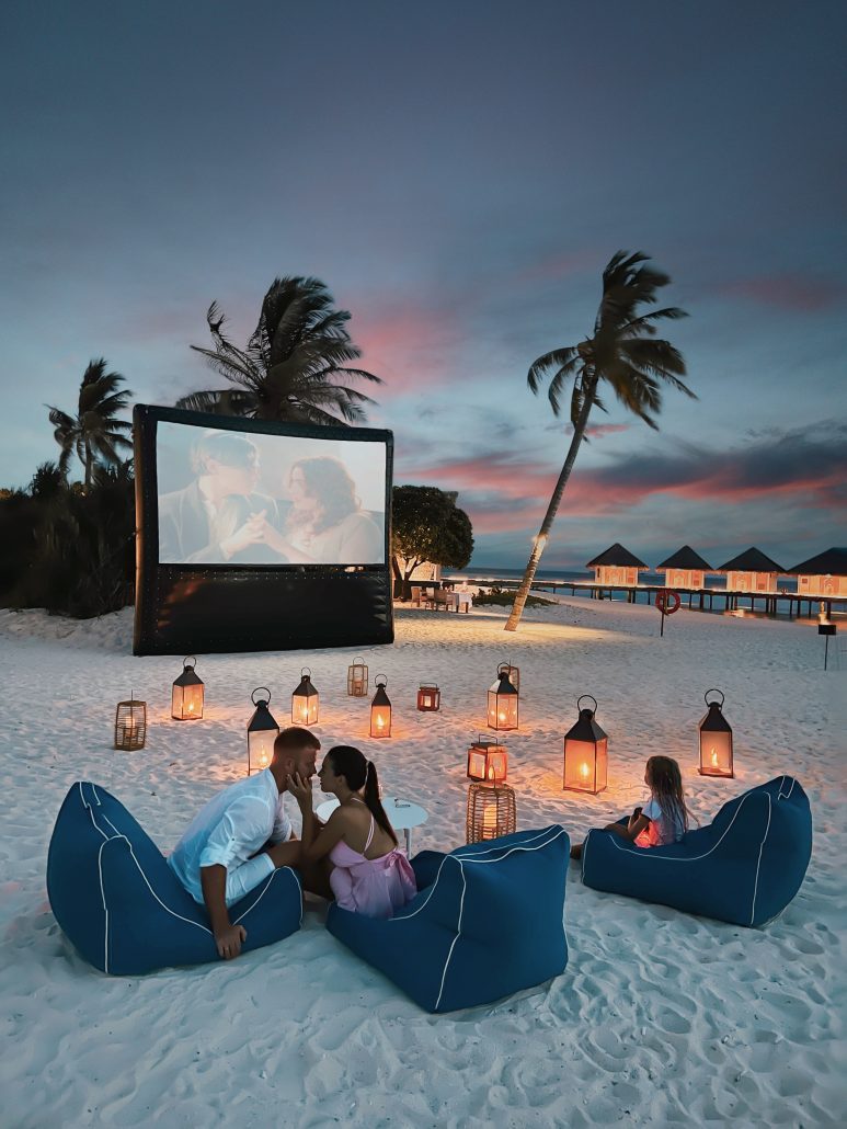 Family Enjoying a Beach Movie Night, Bonding and Relaxing Under the Starry Sky