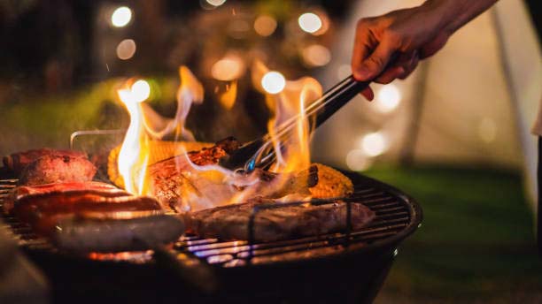 Family making barbecue in dinner party camping at night